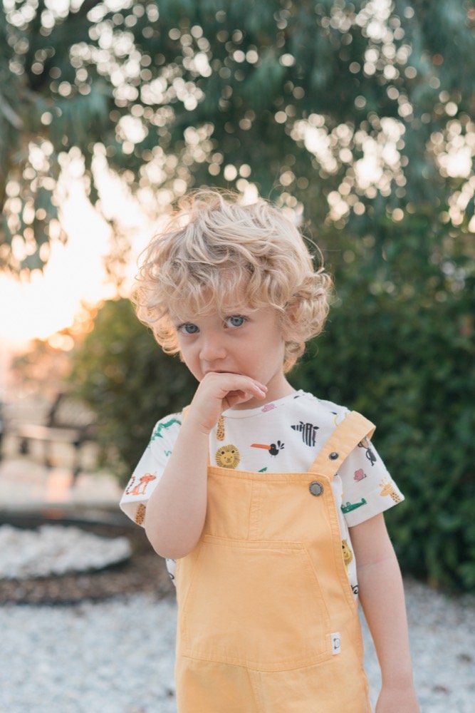 A curly-haired toddler in the garden